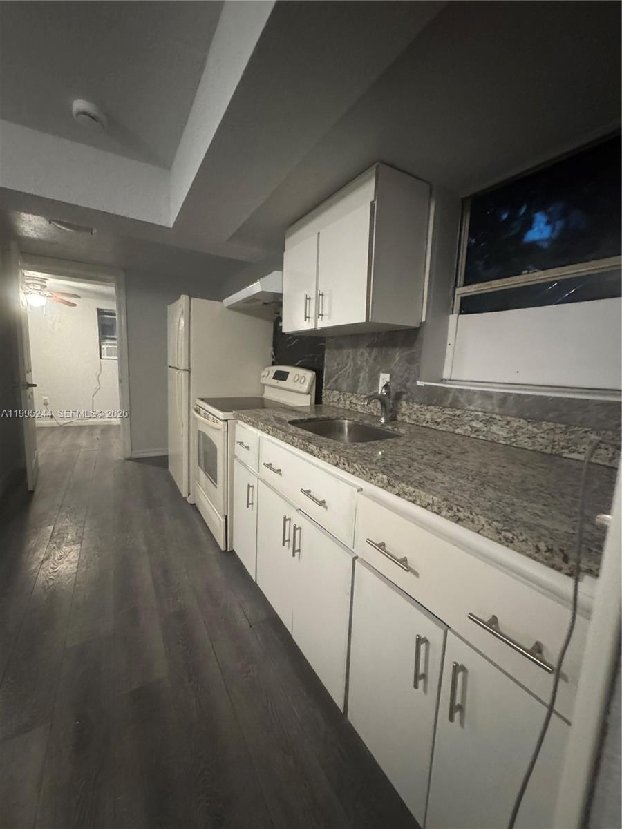 7802 Northwest 8th Avenue, Unit 5 Miami, FL 33150 - Photo 2 of 7 a kitchen with cabinets and wooden floor