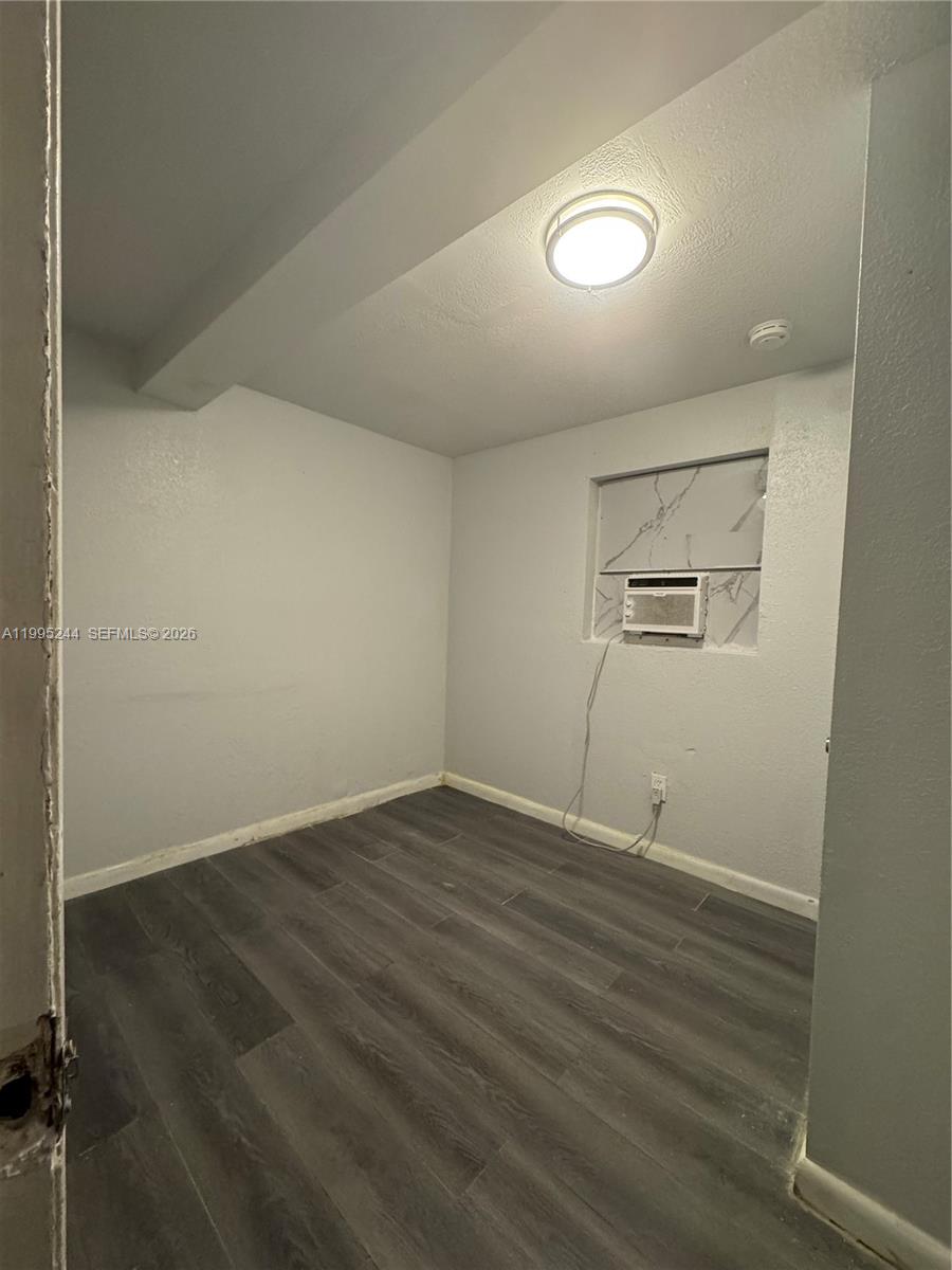 7802 Northwest 8th Avenue, Unit 5 Miami, FL 33150 - Photo 5 of 7 an empty room with wooden floor and windows