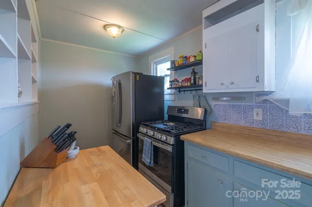 a kitchen with stainless steel appliances granite countertop a stove a refrigerator and a sink