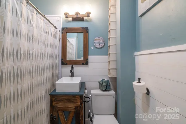 a bathroom with a sink a toilet and mirror