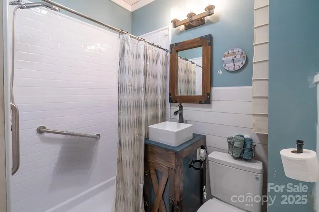 a bathroom with a sink a toilet and mirror