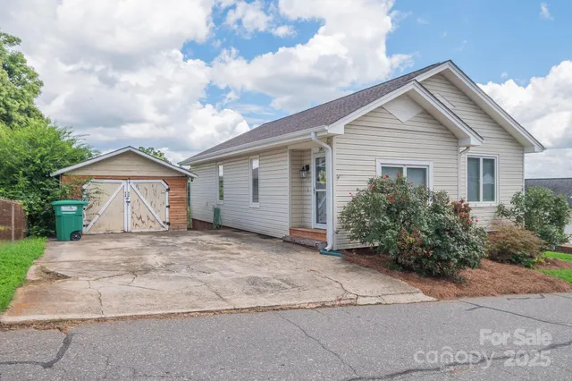 front view of house with a yard and potted plants