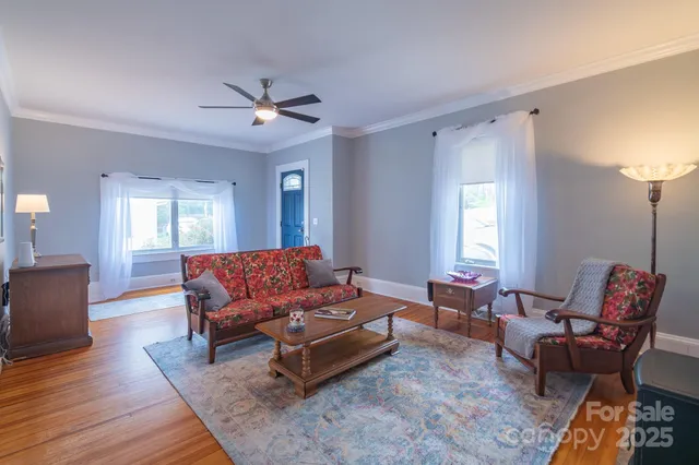 a living room with furniture a chandelier and a window