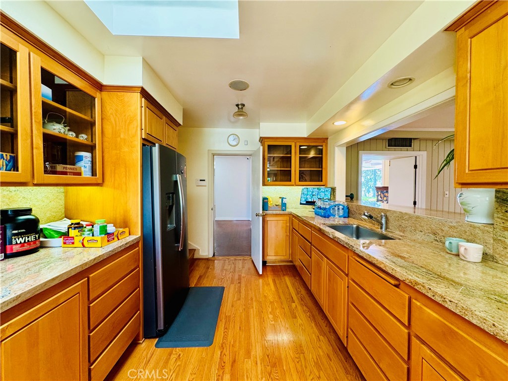 1777 La Cresta Drive Pasadena, CA 91103 - Photo 10 of 31 a large kitchen with stainless steel appliances granite countertop a lot of counter space and a wooden floor