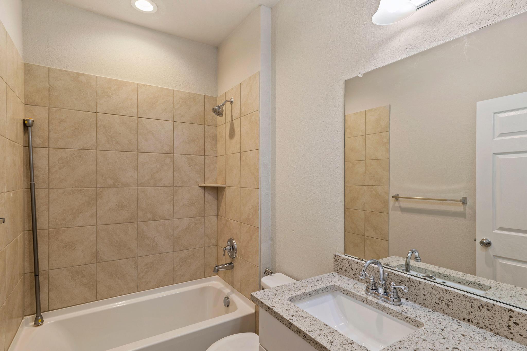 1341 Eagle Ray Street Leander, TX 78641 - Photo 22 of 37 A well-appointed bath features a tiled shower and vanity with integrated sink.