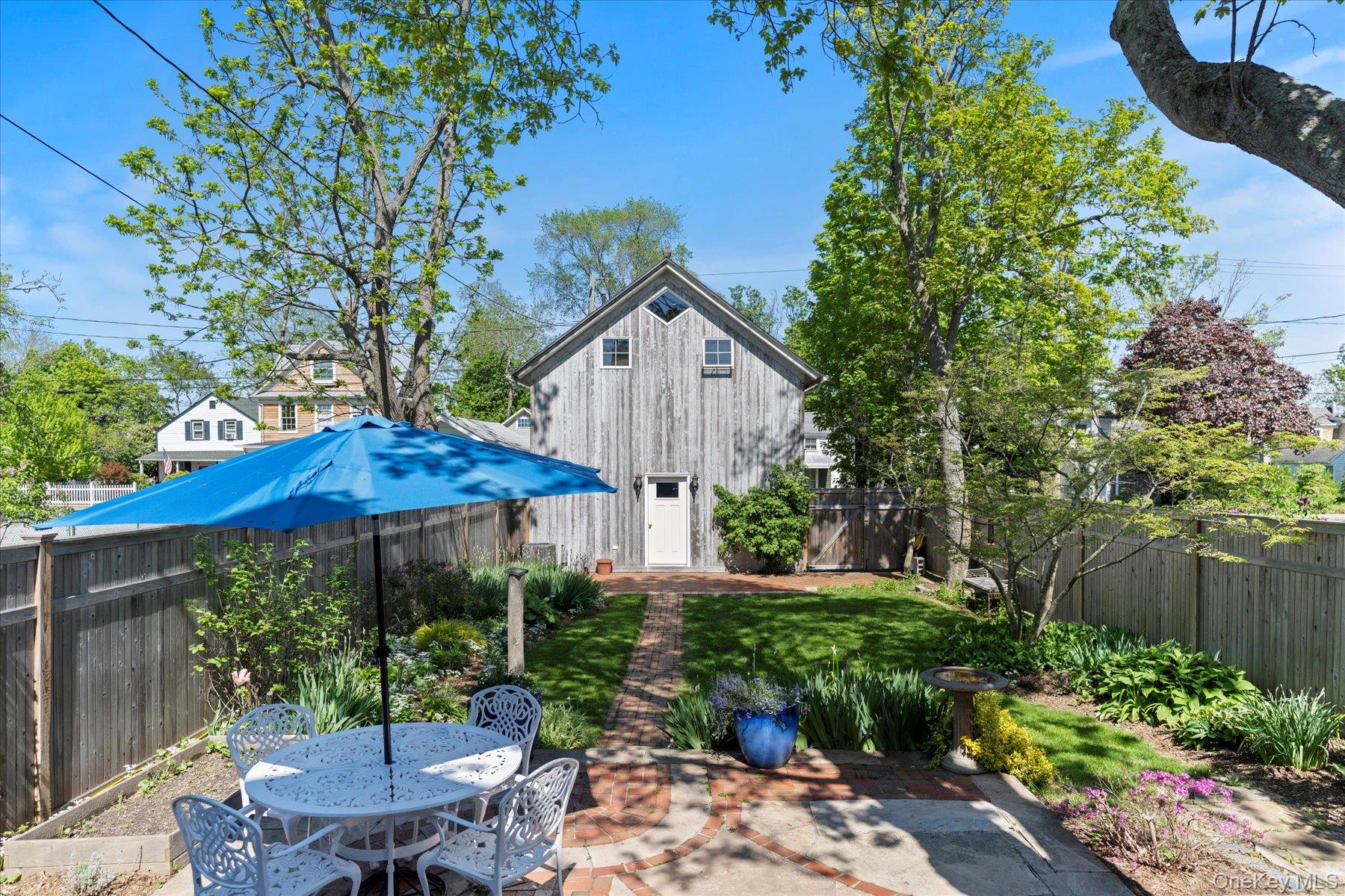604 Main Street Greenport, NY 11944 - Photo 28 of 37 Patio with fenced garden, view toward barn
