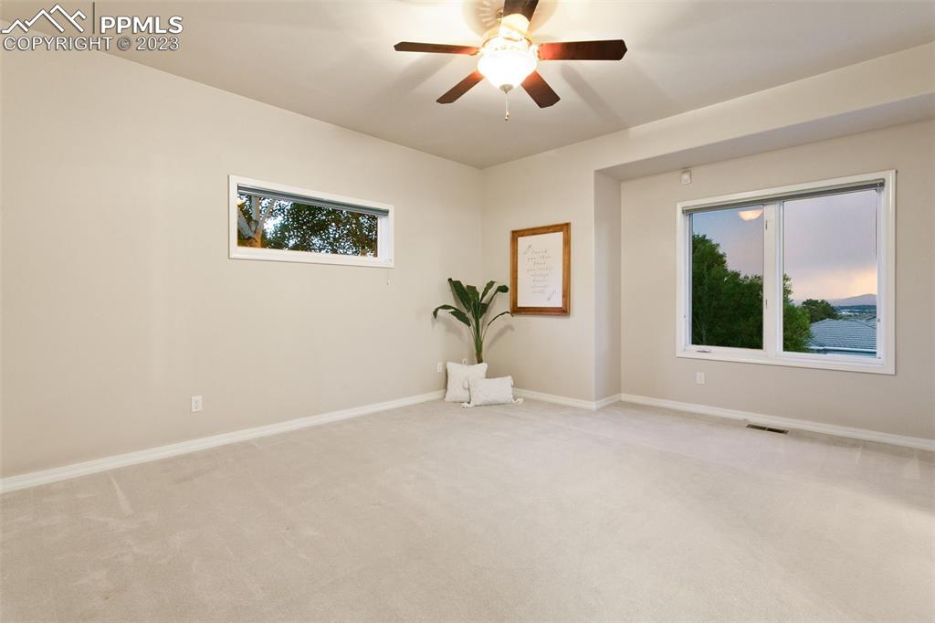 4120 Saddle Rock Road Colorado Springs, CO 80918 - Photo 15 of 50 an empty room with windows and chandelier fan