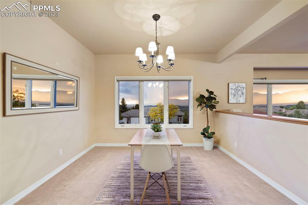 4120 Saddle Rock Road Colorado Springs, CO 80918 - Photo 17 of 50 a view of a dining room with furniture a chandelier and wooden floor