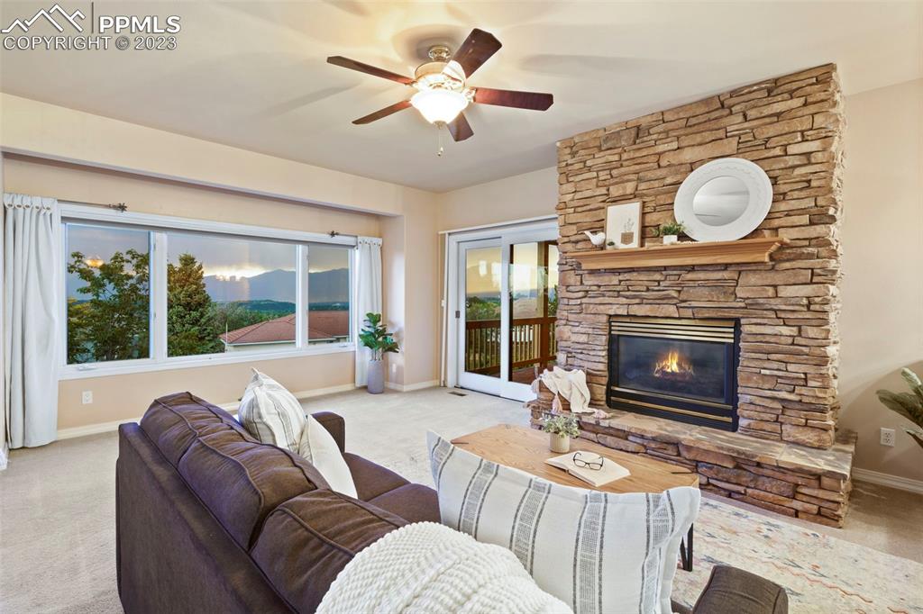 4120 Saddle Rock Road Colorado Springs, CO 80918 - Photo 22 of 50 a living room with furniture a fireplace and a large window