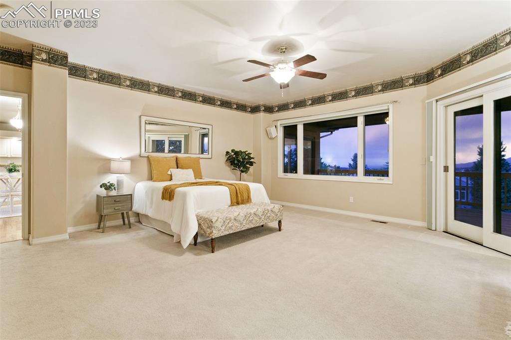 4120 Saddle Rock Road Colorado Springs, CO 80918 - Photo 32 of 50 a spacious bedroom with a large bed and a chandelier