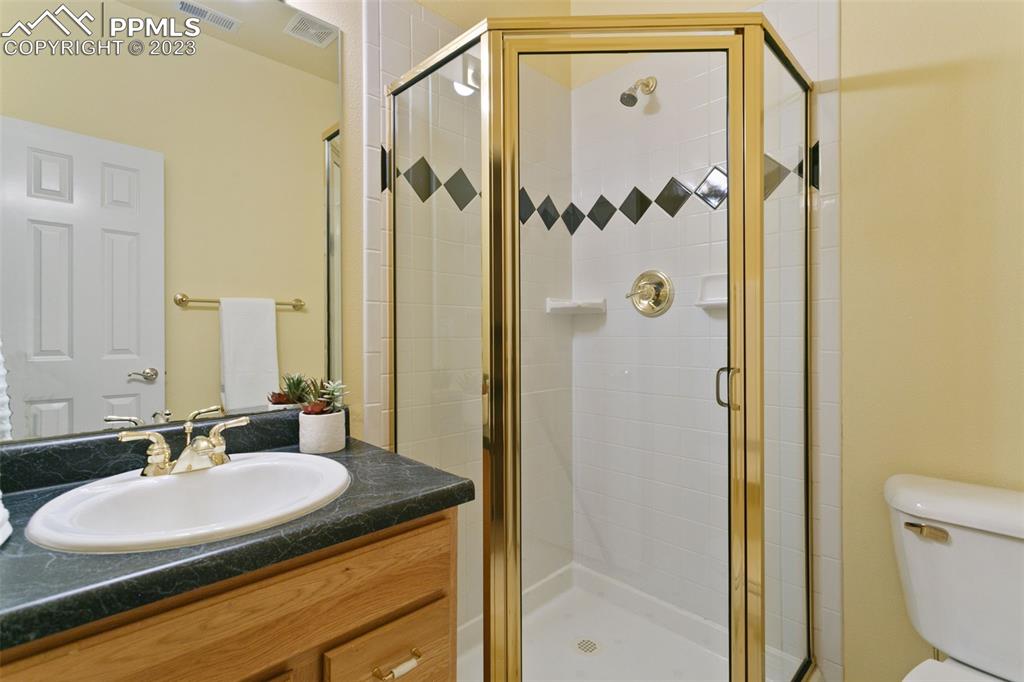 4120 Saddle Rock Road Colorado Springs, CO 80918 - Photo 44 of 50 a bathroom with a granite countertop sink a mirror and a shower