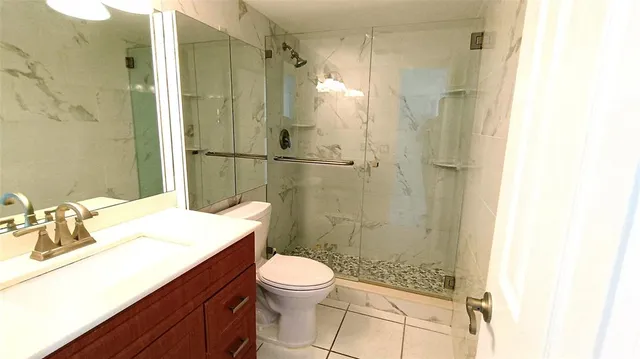 a bathroom with a sink a toilet a shower and a mirror