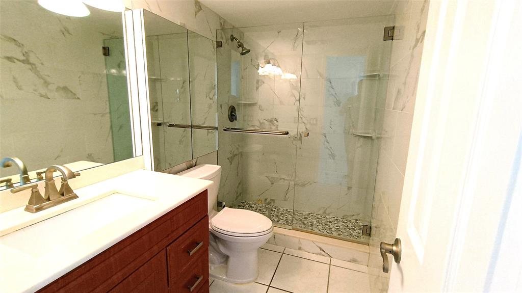 777 South Federal Highway, Unit M301 Pompano Beach, FL 33062 - Photo 7 of 16 a bathroom with a sink a toilet a shower and a mirror