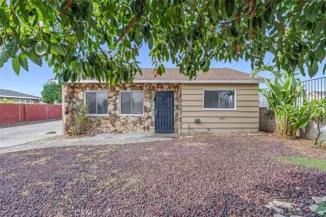 a front view of a house with a tree