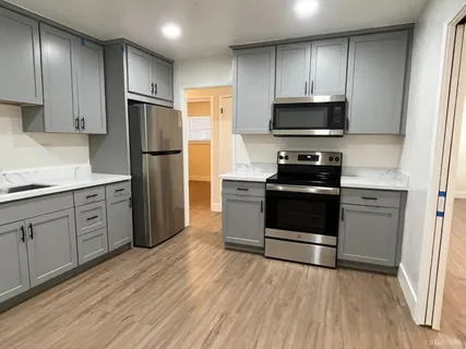 a kitchen with stainless steel appliances a refrigerator stove and microwave