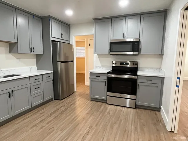 a kitchen with stainless steel appliances a refrigerator stove and microwave