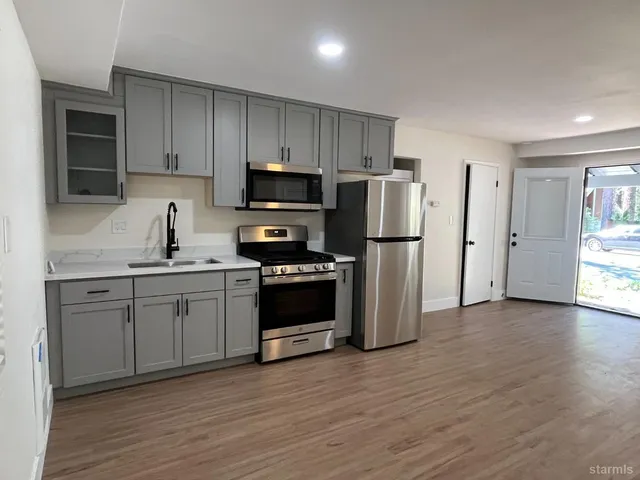 a kitchen with stainless steel appliances a refrigerator stove and sink