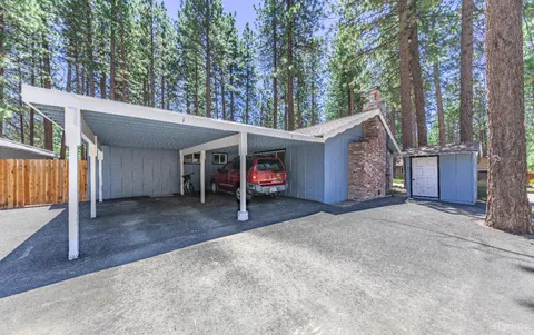 a view of a house with a garage and large tree