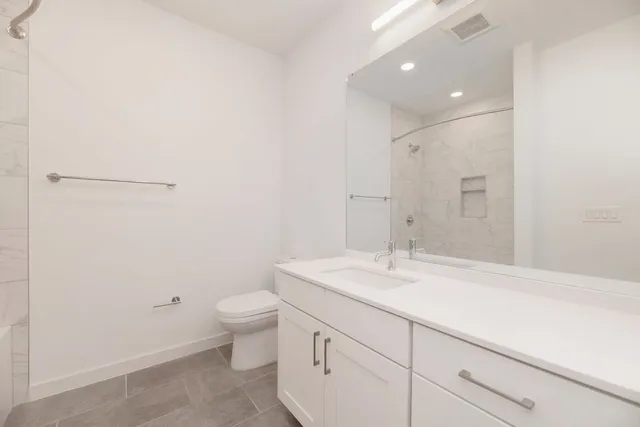 a bathroom with a sink a toilet a mirror and vanity