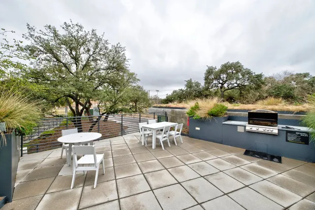 a view of a patio with a dining table and chairs with wooden floor