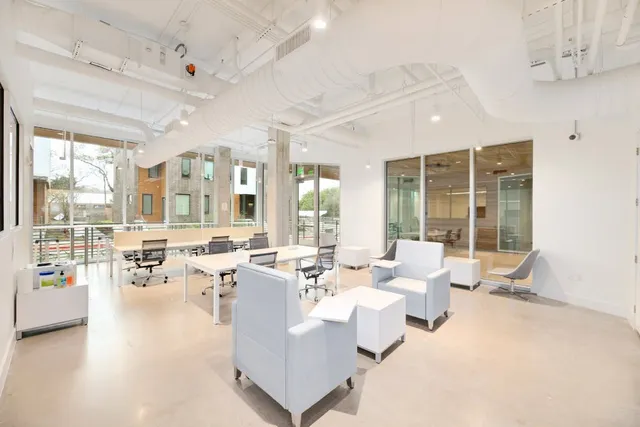 a living room with furniture large window and chairs