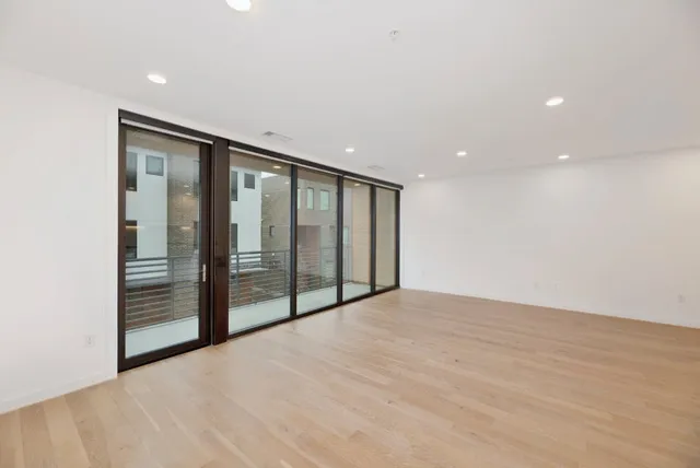 a view of an empty room with wooden floor