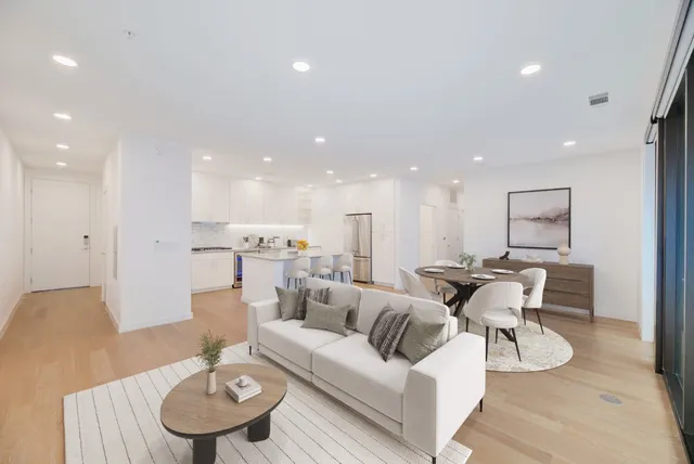 a living room with furniture and a dining table with wooden floor