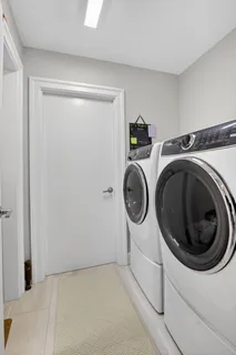 a view of a lake with couches table and chairs under an umbrella