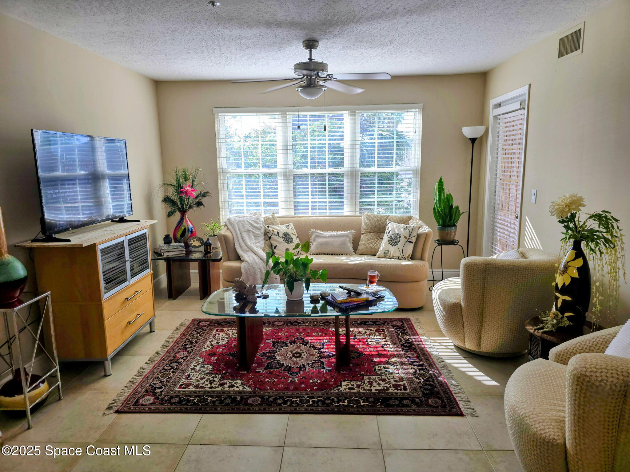 7667 North Wickham Road, Unit 416 Melbourne, FL 32940 - Photo 3 of 30 a living room with furniture a rug and a chandelier