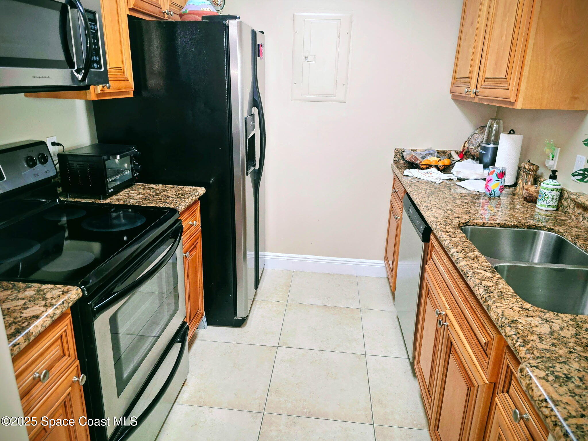 7667 North Wickham Road, Unit 416 Melbourne, FL 32940 - Photo 6 of 30 a kitchen with granite countertop a refrigerator stove and sink