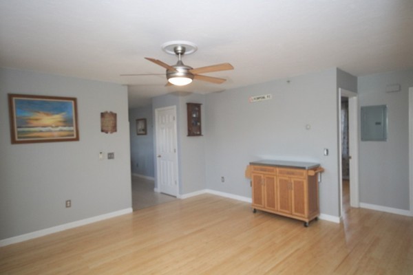 25 George Street, Unit 5 Dudley, MA 01571 - Photo 22 of 42 an empty room with wooden floor and ceiling fan