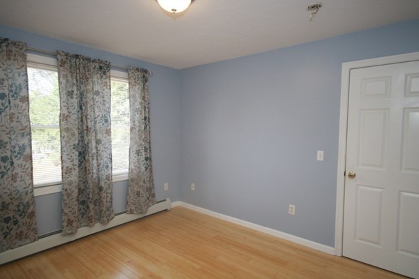 25 George Street, Unit 5 Dudley, MA 01571 - Photo 23 of 42 a view of an empty room with wooden floor and a window
