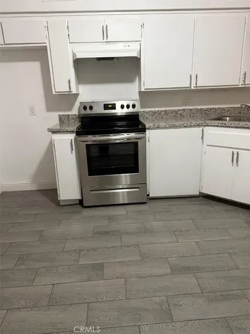 a stove top oven sitting inside of a kitchen