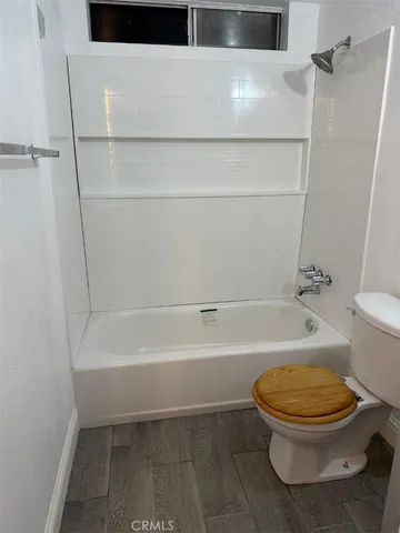 a bathroom with a toilet and a bath tub