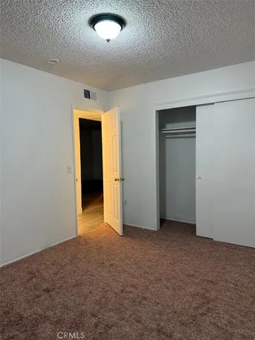 an empty room with closet and a hallway