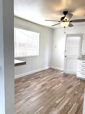 a view of an empty room with a window and wooden floor