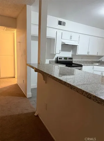 a kitchen with stainless steel appliances granite countertop a sink a stove and a refrigerator