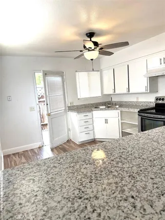 a kitchen with granite countertop a stove a sink and a refrigerator