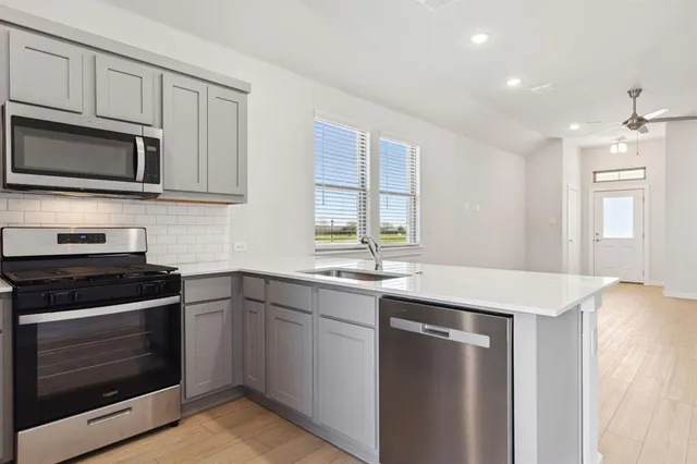 a view of kitchen with stainless steel appliances cabinets and wooden floor