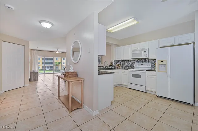 a kitchen with white cabinets and white appliances