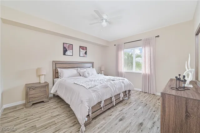 a bedroom with a bed and a dresser with wooden floor