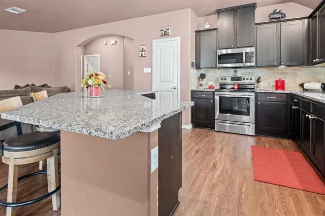 a kitchen with stainless steel appliances granite countertop a sink stove and refrigerator