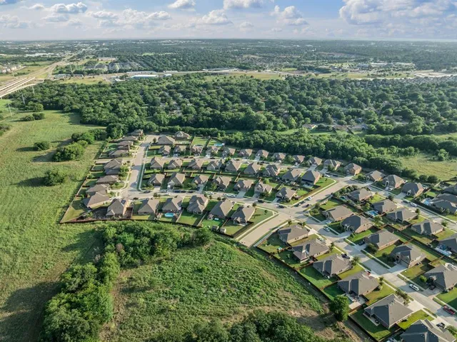 an aerial view of residential houses with outdoor space and trees