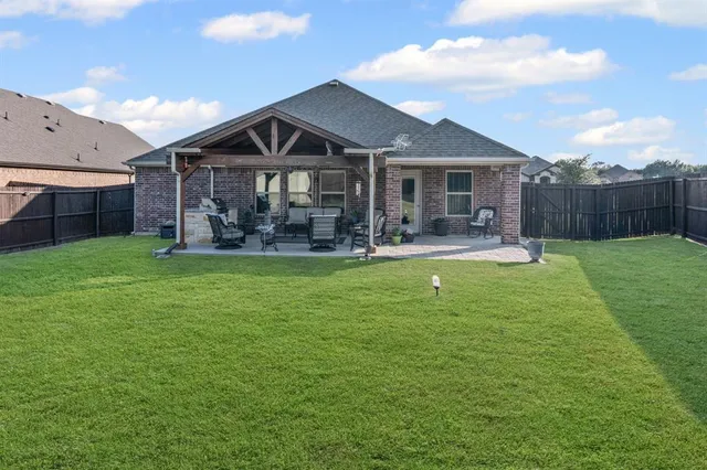 a view of a house with a yard and sitting area