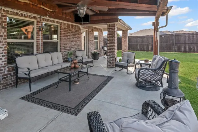 a living room with patio furniture and a floor to ceiling window