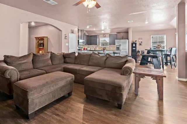 a living room with furniture and a view of kitchen