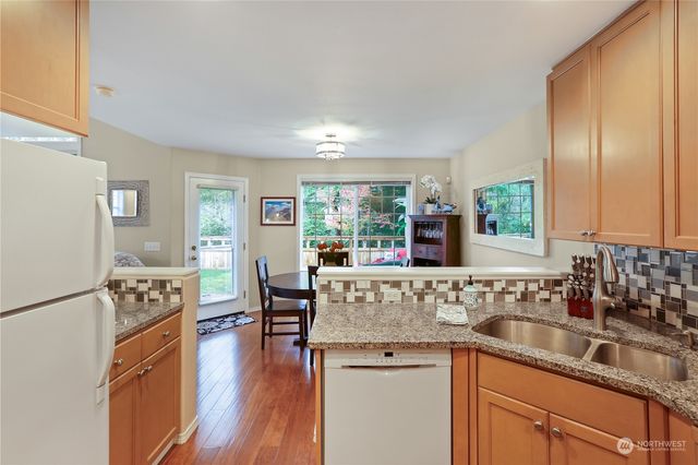 a kitchen with stainless steel appliances granite countertop a sink stove and wooden floor