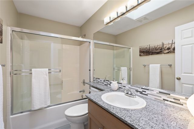 a bathroom with a granite countertop sink toilet and shower