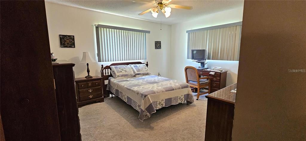 10881 Southwest 79th Terrace Ocala, FL 34476 - Photo 13 of 38 a bedroom with a bed and a chandelier