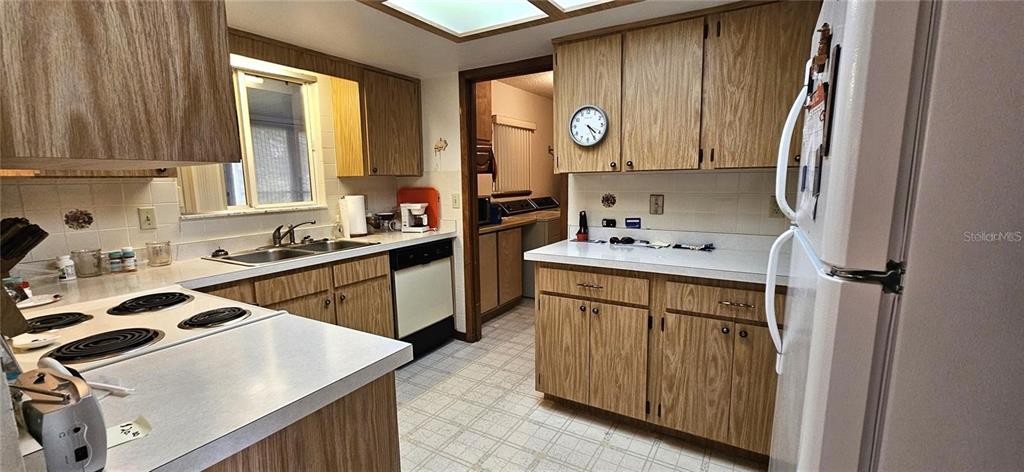10881 Southwest 79th Terrace Ocala, FL 34476 - Photo 9 of 38 a kitchen with a sink a stove cabinets and a window